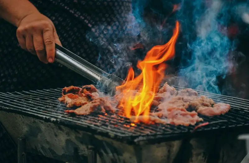 Grille de barbecue en train de cuire avec une flamme